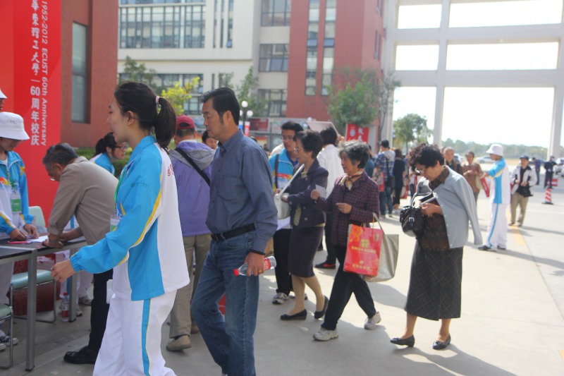 今天，返校观礼的<font color=red>校友</font>们在志愿者的带领下纷纷在签到簿上签名，他们要把对母校的情谊和祝福也一并留下。